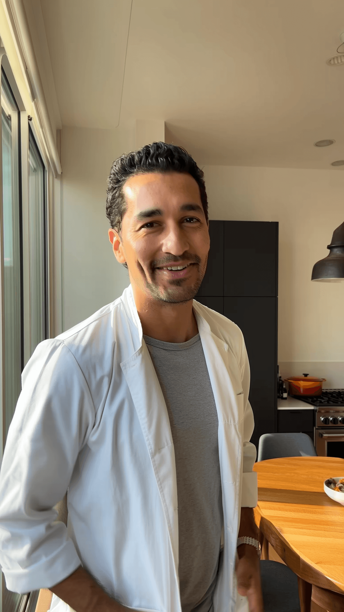 Chef Néstor Mendoza en su cocina moderna, sonriendo mientras habla sobre su experiencia de empezar como lavaloza